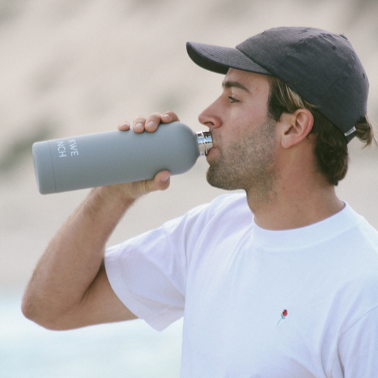 man drinking from stainless steel water bottle