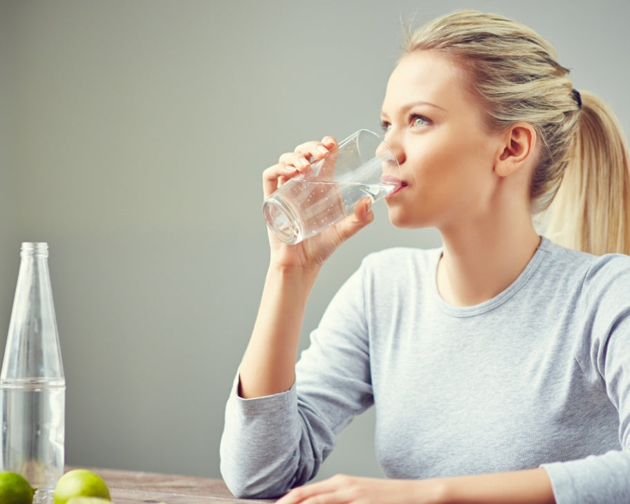 Lady drinking water thinking about water diet.